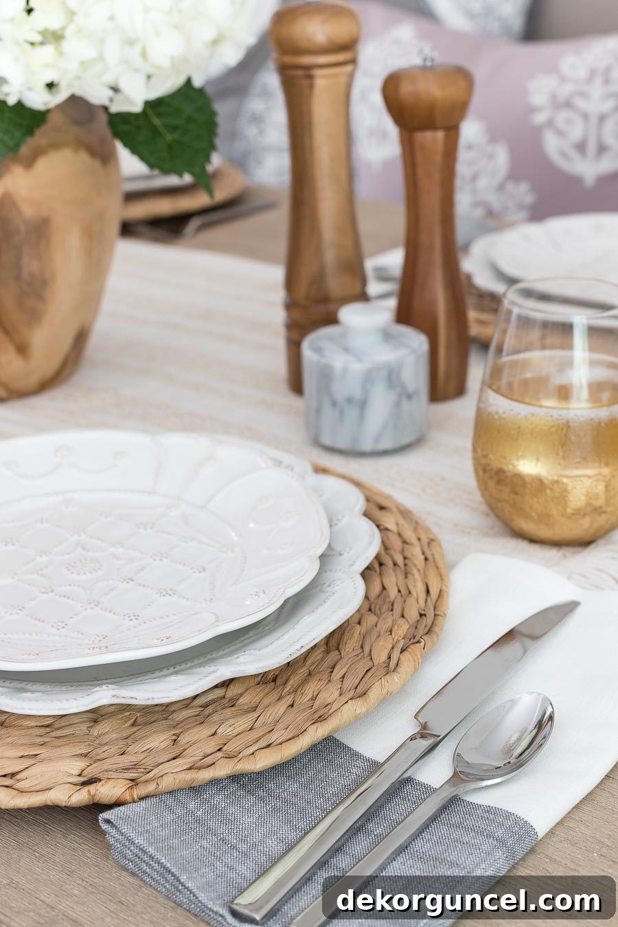 A beautiful and simple table setting, featuring textured woven chargers and stylish black stripe napkins, creating an inviting and chic dining experience.