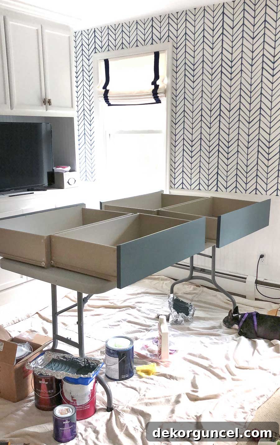 A cat supervising the painting of IKEA dresser drawers on a folding table, demonstrating a practical setup for DIY furniture makeovers.