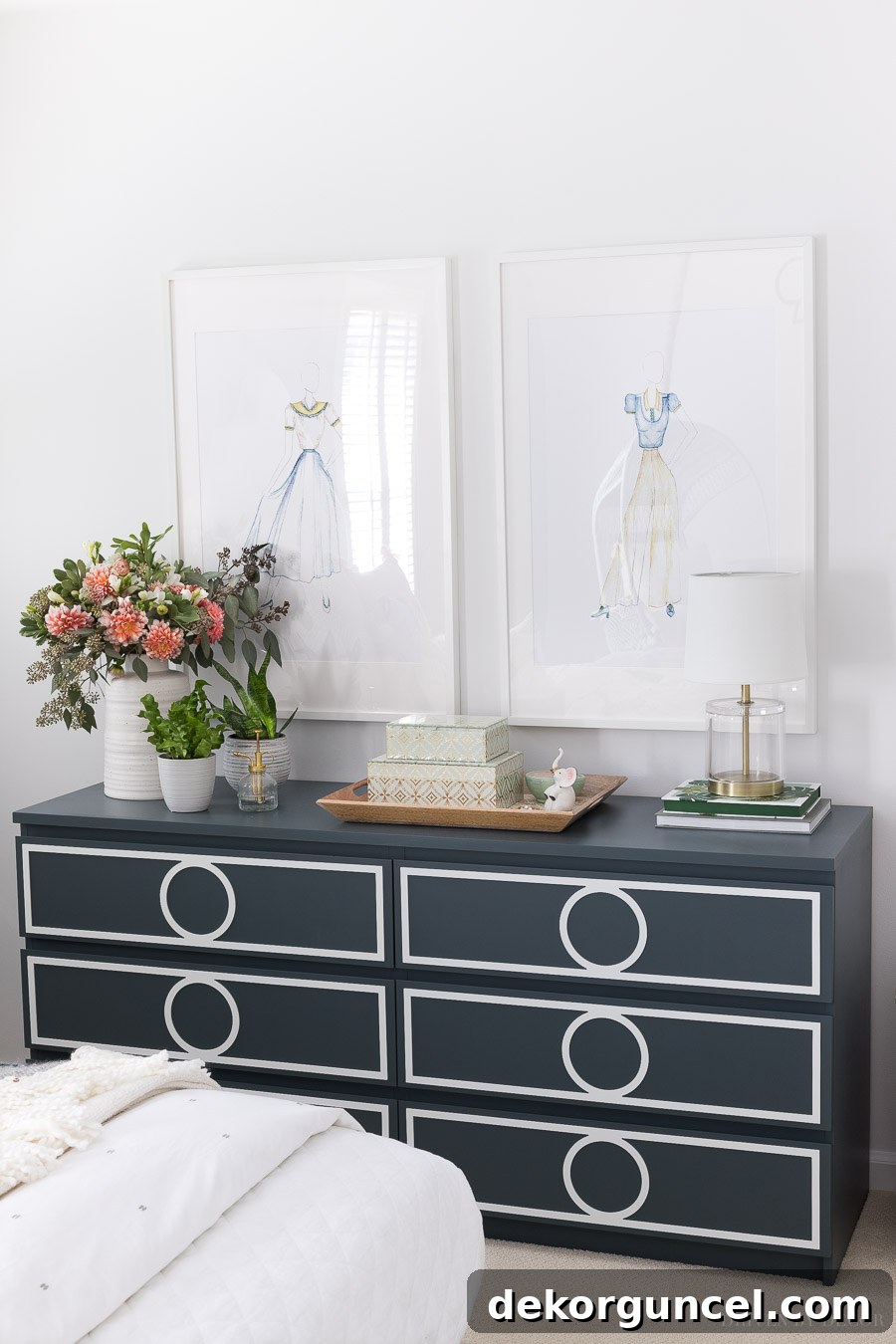 Two large white IKEA frames showcasing enlarged fashion design sketches by a child, serving as unique and inexpensive bedroom art in a boho-inspired room.