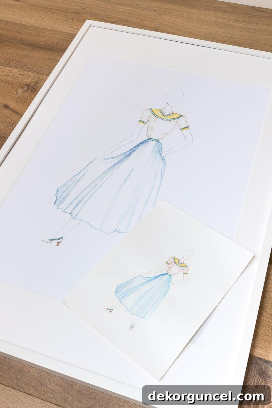 Enlarged children's fashion design sketches framed in simple white frames, showcasing a creative and inexpensive way to add meaningful wall art to a boho bedroom.