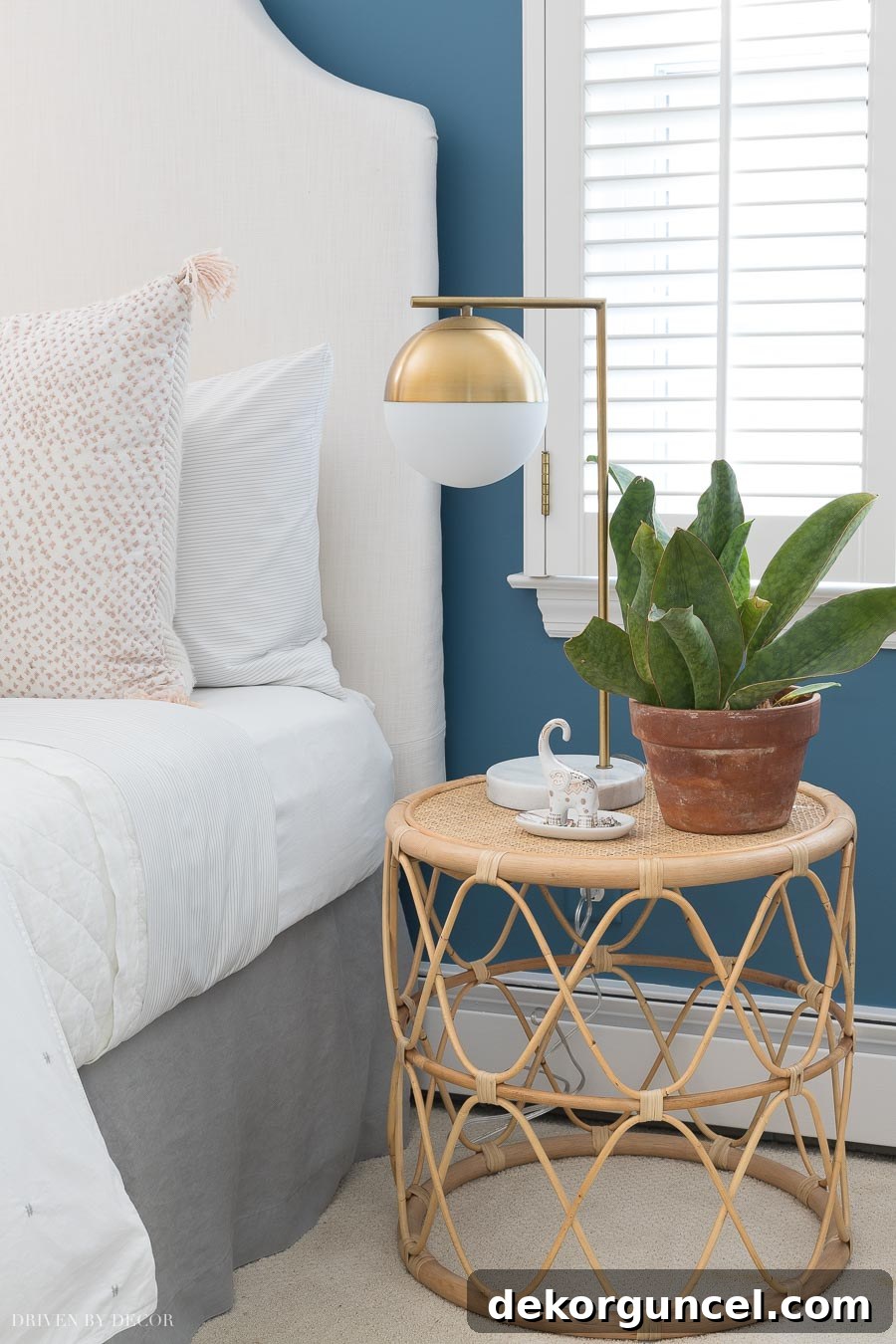A stylish rattan nightstand, doubling as an end table, providing natural texture and bohemian charm to a beautifully designed bedroom.