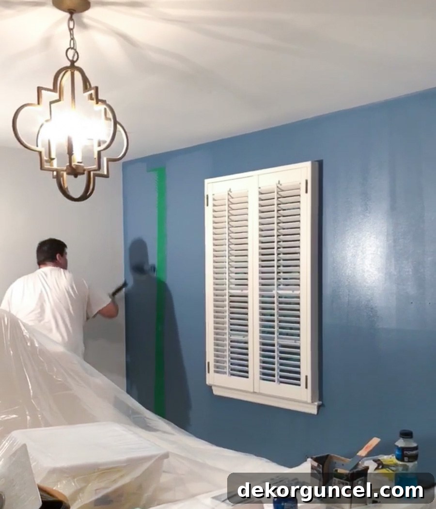 Before and after of a bedroom accent wall, transforming a vibrant green to a calming Behr Marquee Blueprint, highlighting the paint's exceptional one-coat coverage.