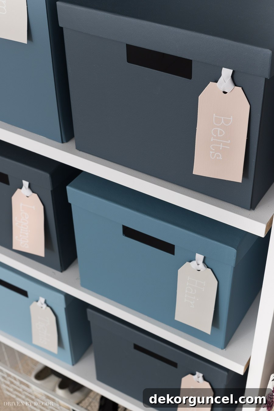 A vibrant display of storage boxes painted in a gradient of Behr Marquee blue shades, including Undersea, Shipwreck, Blueprint, and Dolphin Blue, for stylish closet organization.