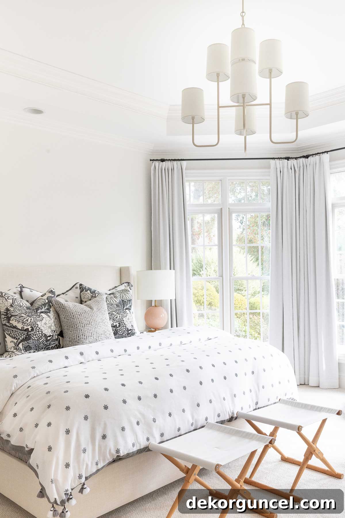 Behind the Illumination: My Home's Fixture Selections 11 A beautifully designed bedroom featuring a tiered chandelier with shades, creating a soft and elegant ambiance.