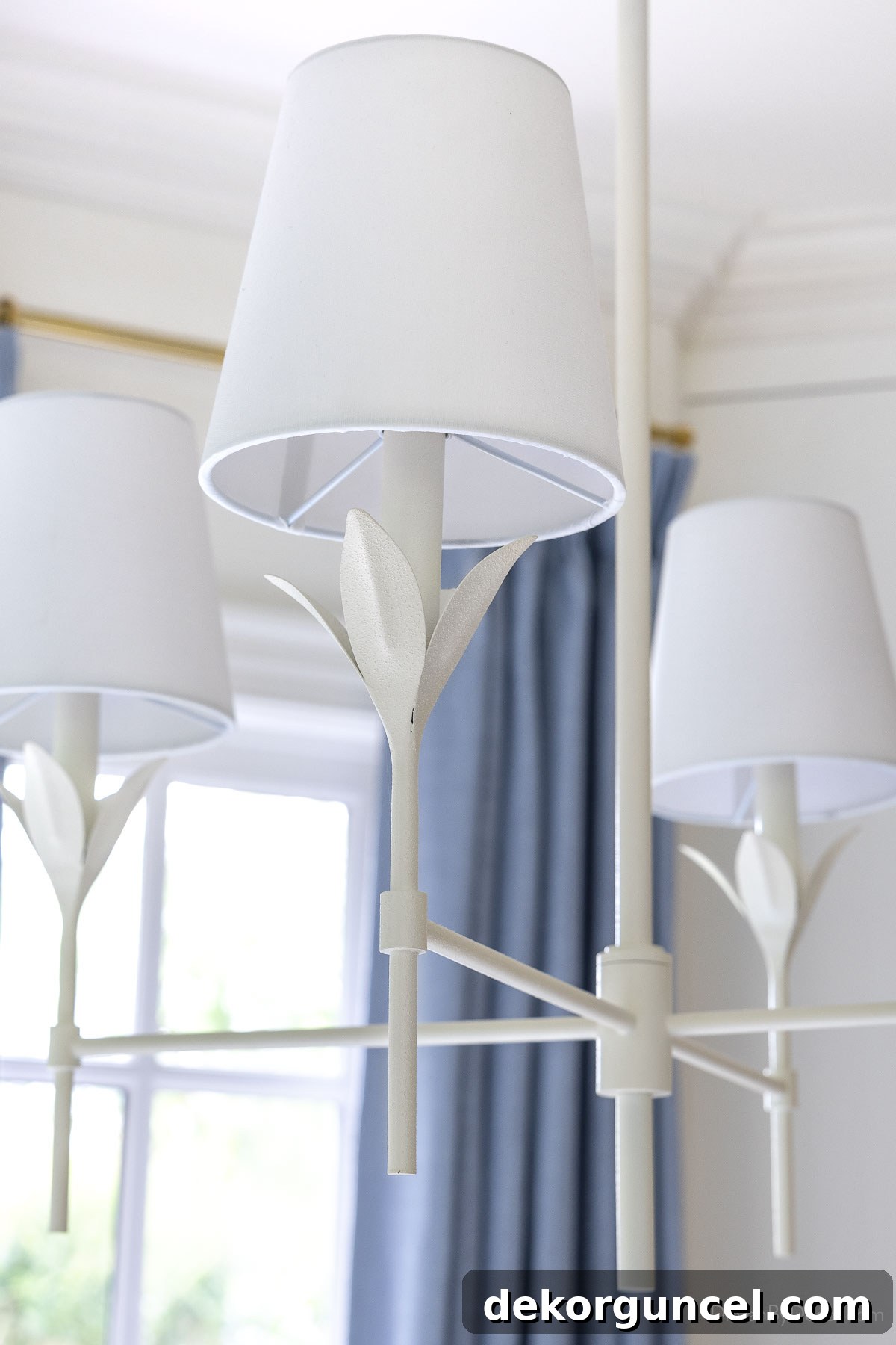 Behind the Illumination: My Home's Fixture Selections 14 Close-up of a matte white chandelier featuring a delicate petal design on each arm, showcasing its intricate details.