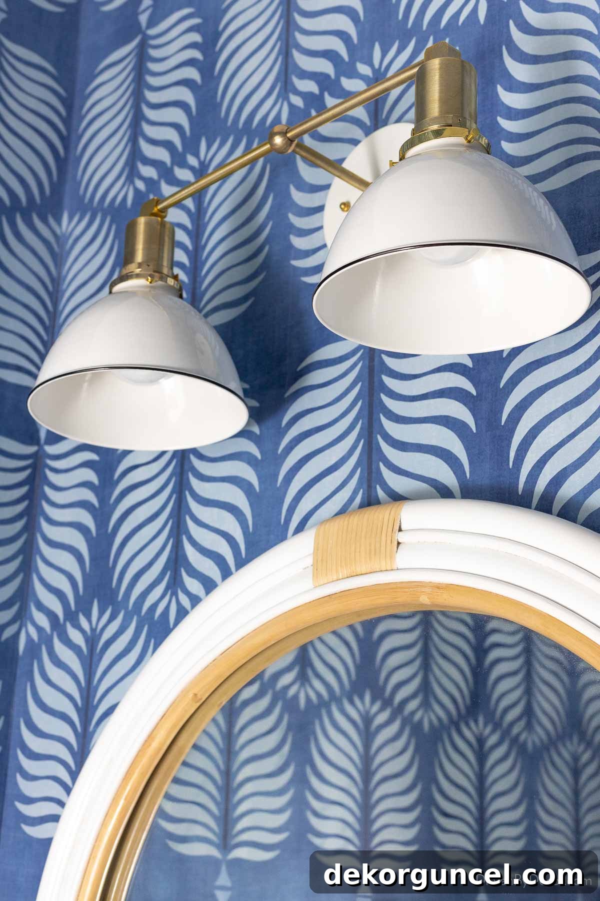 Behind the Illumination: My Home's Fixture Selections 38 A two-light brass and white bathroom sconce gracefully mounted over a round rattan mirror in a powder room.