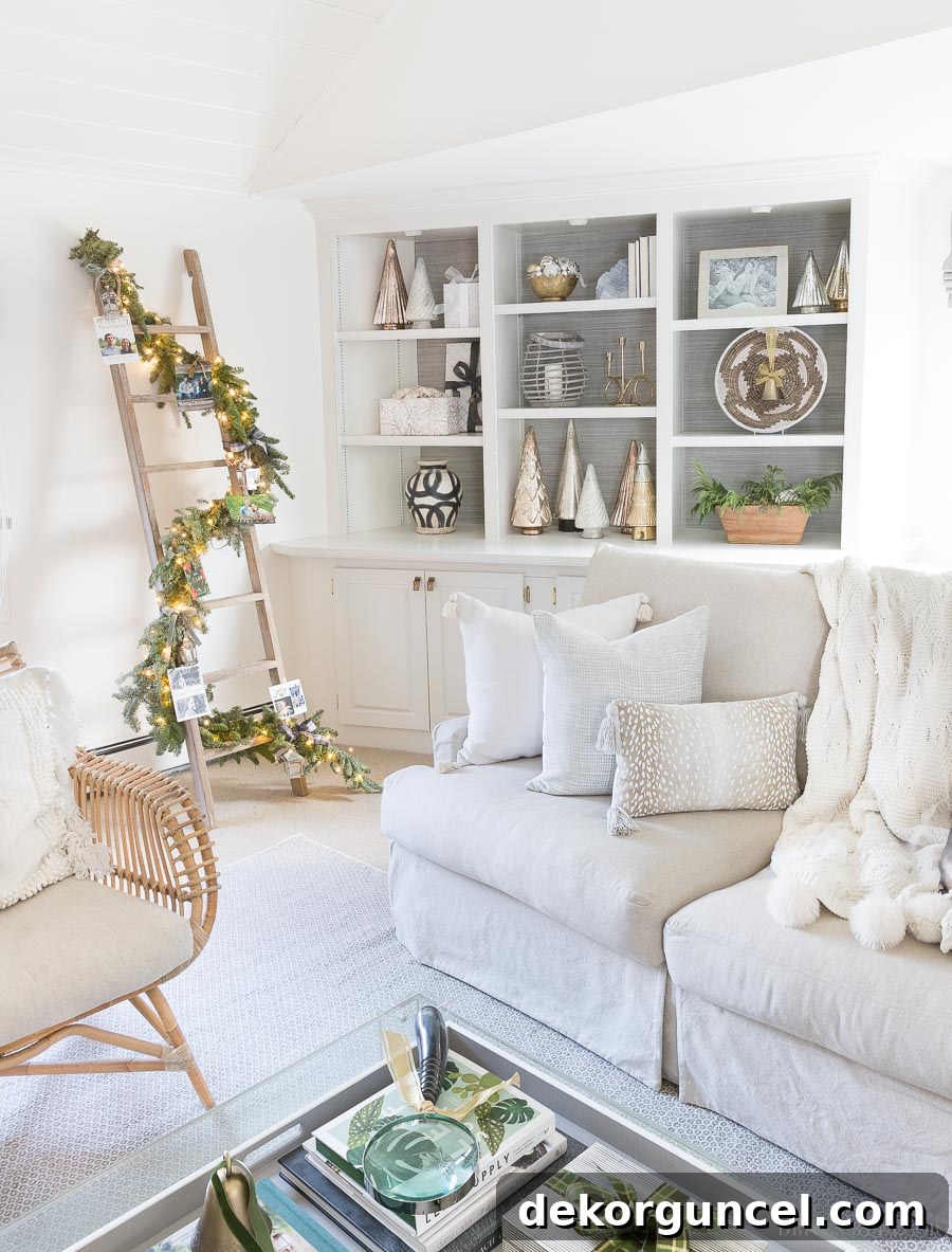 Inspiring Christmas card display idea: cards tied onto a garland-wrapped whitewashed ladder in a cozy living room