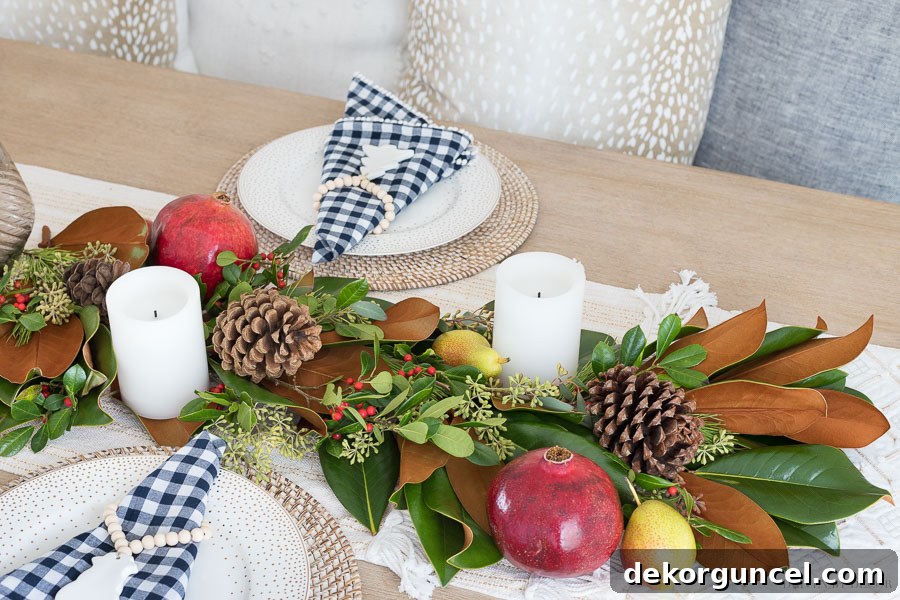 Achieve a Bountiful Look: The Final Step to Creating a Fresh Greenery Table Runner by Filling Gaps with Magnolia Leaves, Eucalyptus, Berries, Pinecones, Pomegranates, and Pears.
