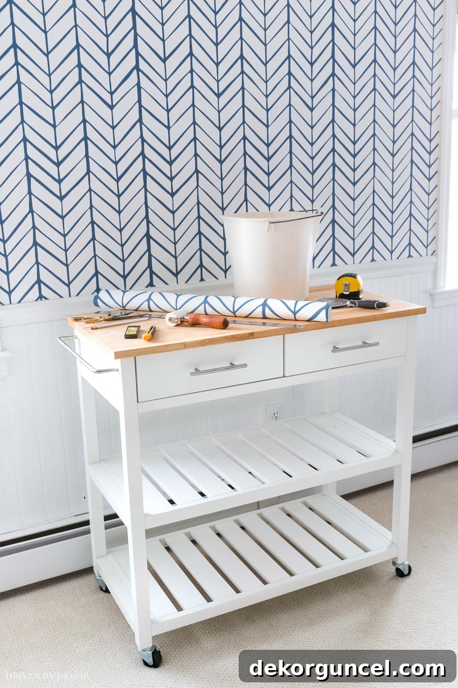 A rolling kitchen cart transformed into a mobile workstation, perfect for holding wallpapering or painting supplies.
