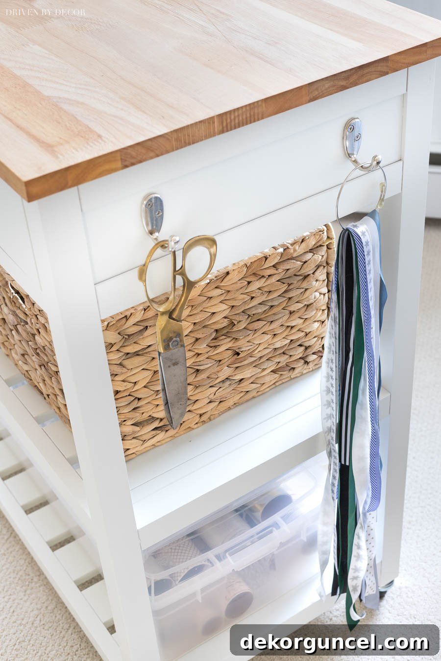 The side of the gift wrapping station cart, showing hooks expertly used for hanging scissors and various short ribbon pieces.