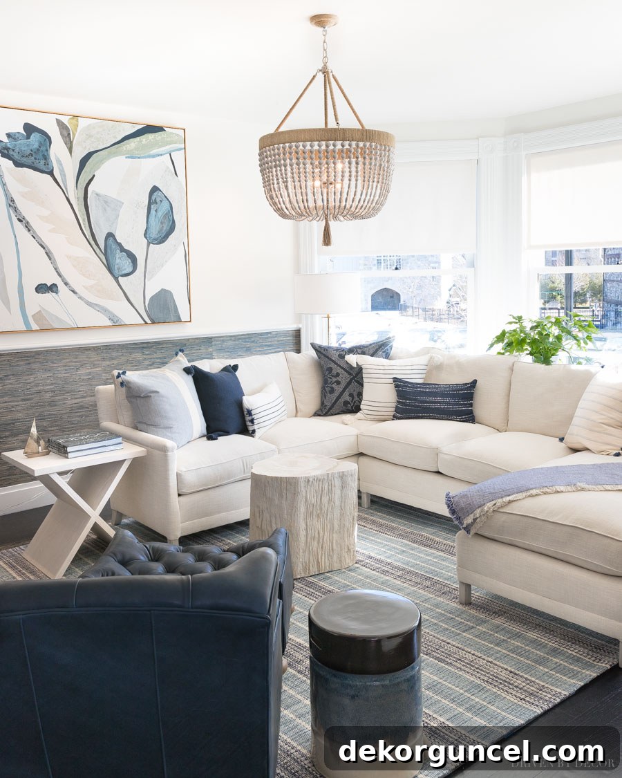 An elegant blue and white living room featuring Serena & Lily grasscloth wallpaper below the chair rail, complementing curated furniture and decor.