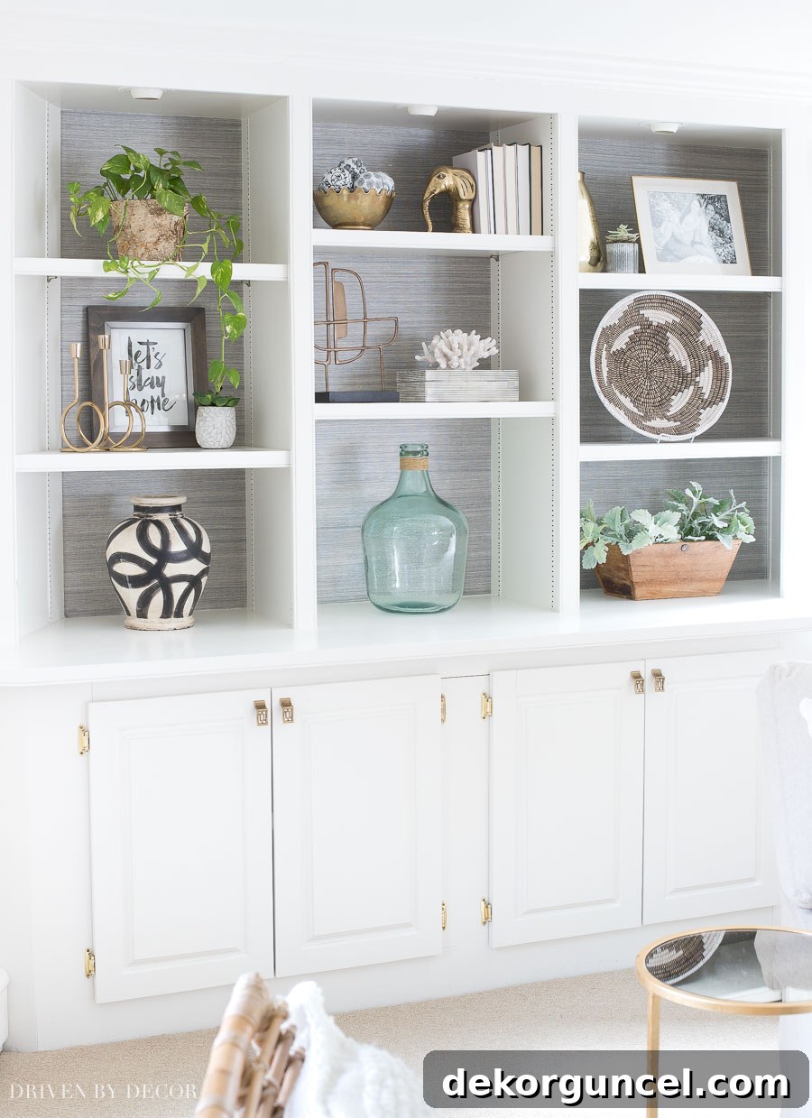 Charcoal grasscloth wallpaper lining the back of bookcases in a family room, adding depth, texture, and sophistication.
