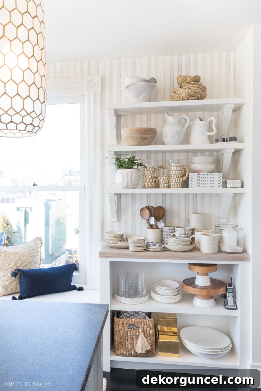 Striped wallpaper in a warm Sand hue used behind open shelving in a Serena & Lily kitchen, offering a classic, chic, and subtly textured look.