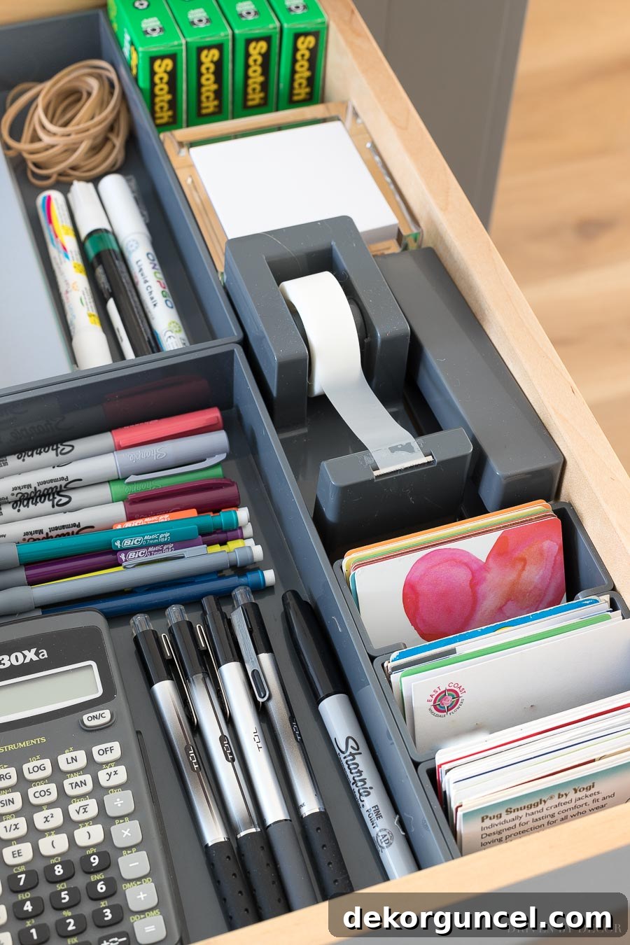 A kitchen command center in a hidden drawer holding tape, stapler, and all sorts of other essentials!