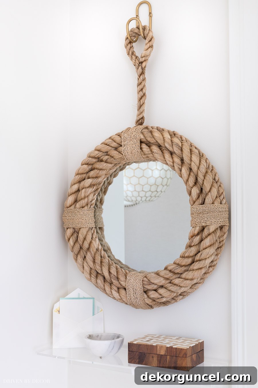 A stylish pairing of a rope mirror and a small acrylic shelf, offering cute and practical decor for a small entryway.