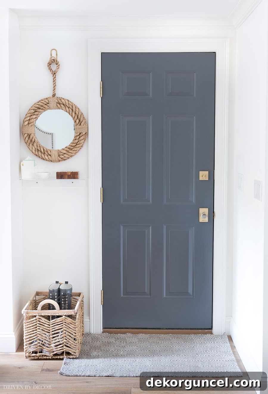Appreciate the thoughtful small details of this garage entryway, including the beautifully painted door, inviting rug, decorative mirror, and practical shelf.