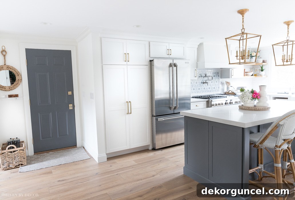A gorgeous dark gray paint color, Benjamin Moore Charcoal Slate, on the entryway door, perfectly matching the kitchen island for a cohesive look.