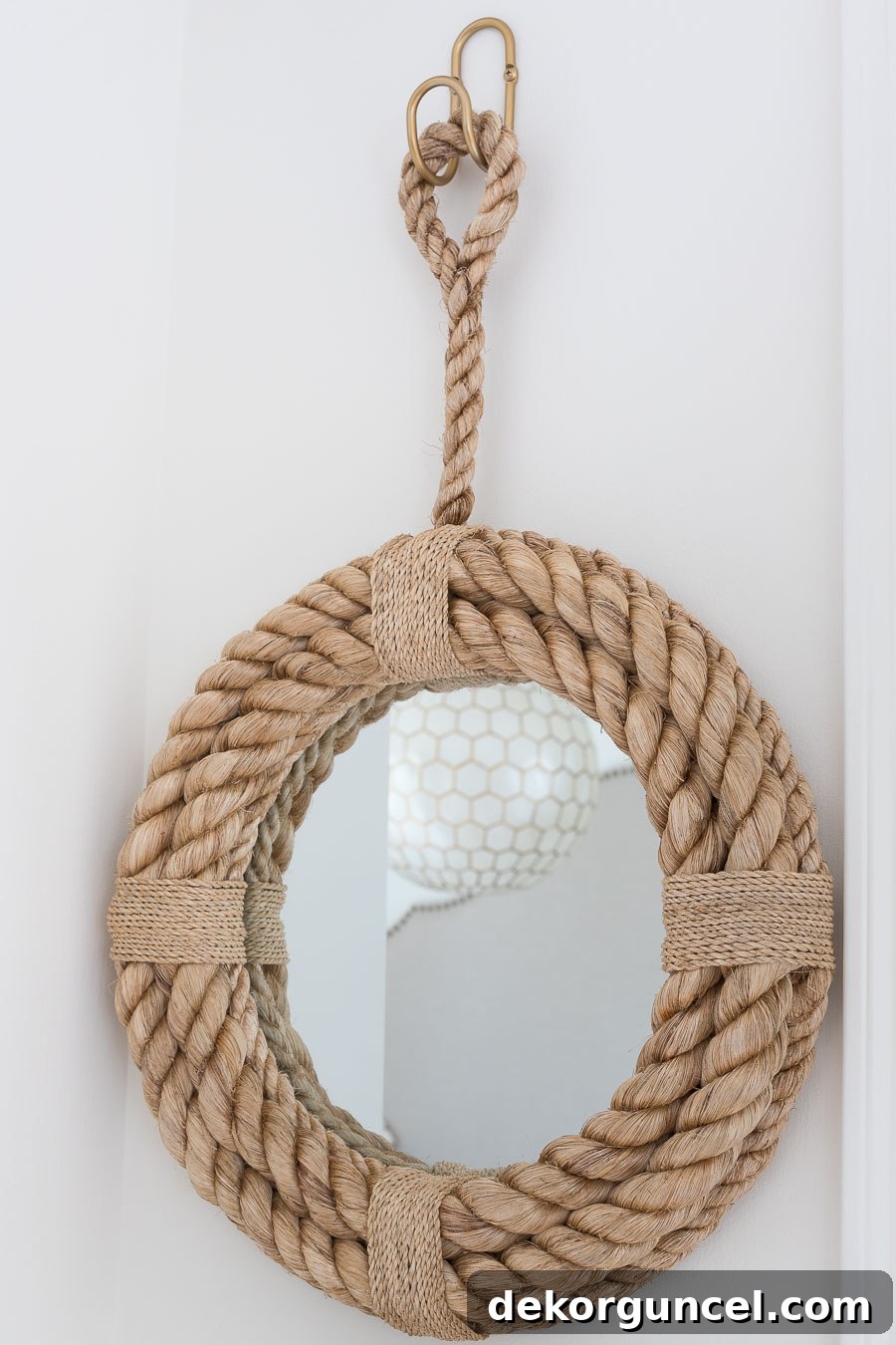 A darling round rope mirror, perfectly sized for a small entryway leading out to the garage, adding charm and functionality.