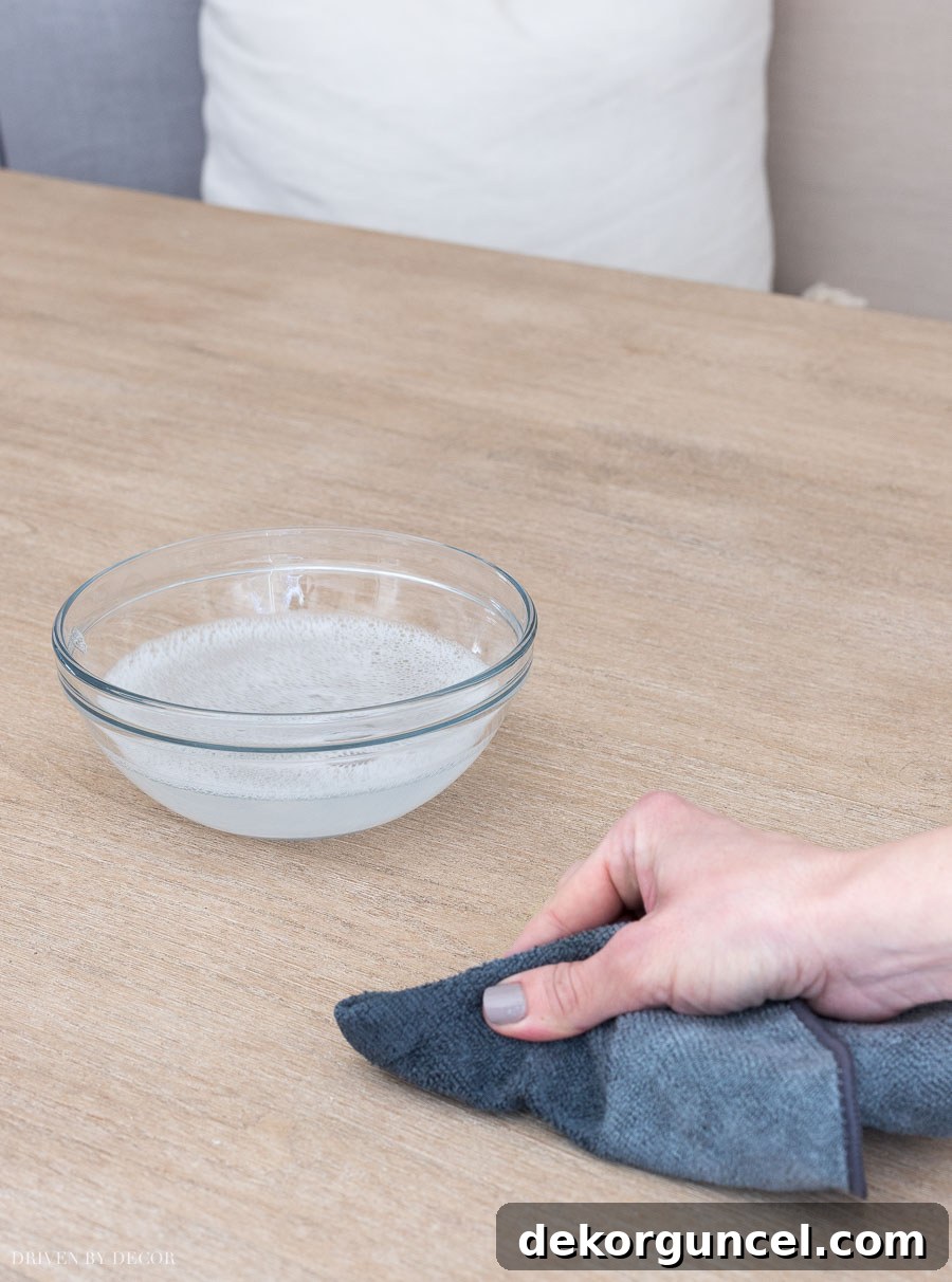 Detailed instructions on how to effectively clean a wood dining table before applying a protective wax finish.