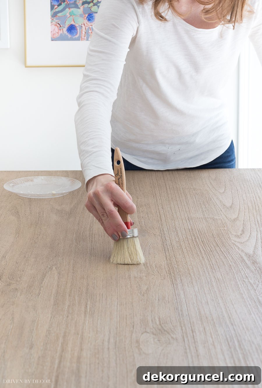 Step-by-step instructions and visual demonstration on how to apply a thin coat of wax to a wood table for sealing.