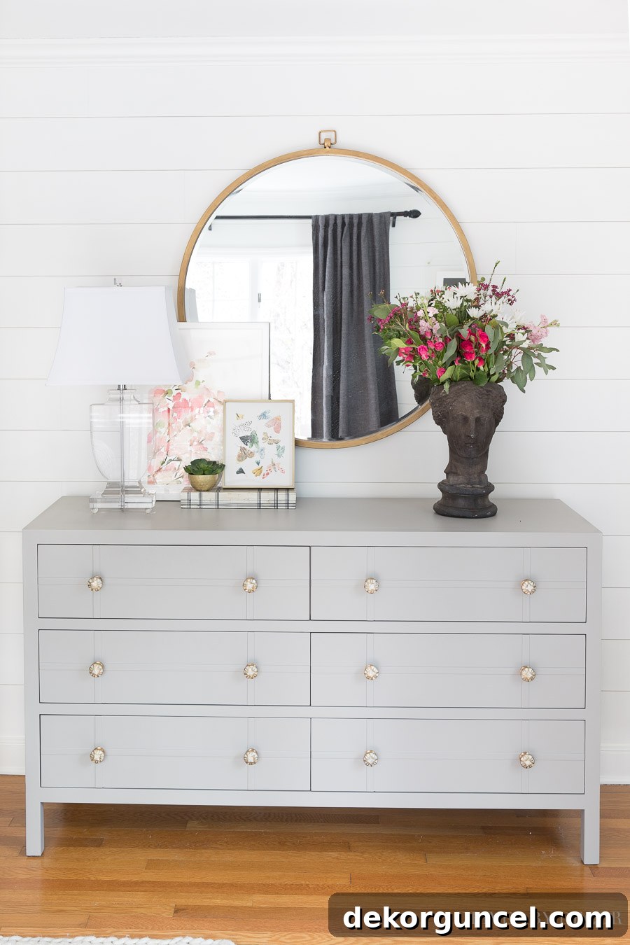 Gray bedroom dresser, large round mirror, and acrylic lamp - perfect for a bedroom!