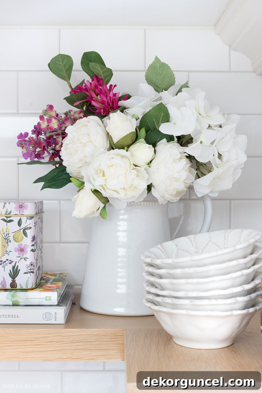 These realistic faux flowers in a pitcher are perfect for dressing up the look of your shelves! Creative styling for open shelving.