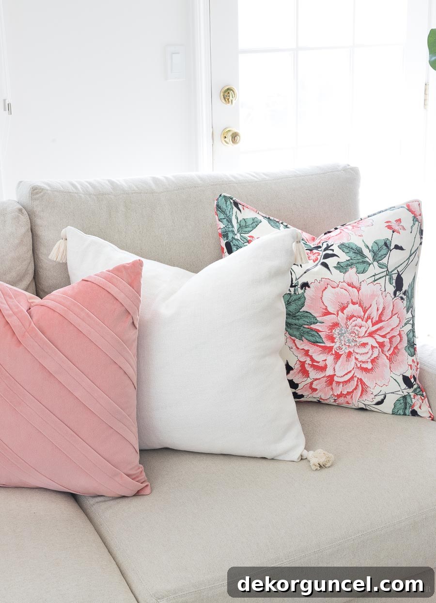 A beautiful spring pillow combination featuring a vintage floral pattern, a solid cream tasseled pillow, and a soft pleated blush velvet pillow.