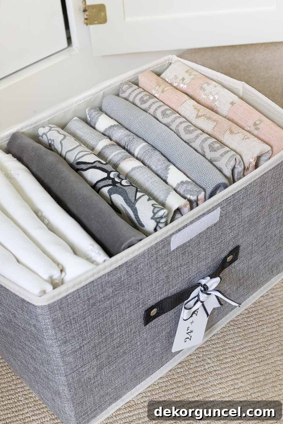 Lidded fabric storage boxes filled with vertically folded pillow covers, demonstrating the KonMari method for organization.