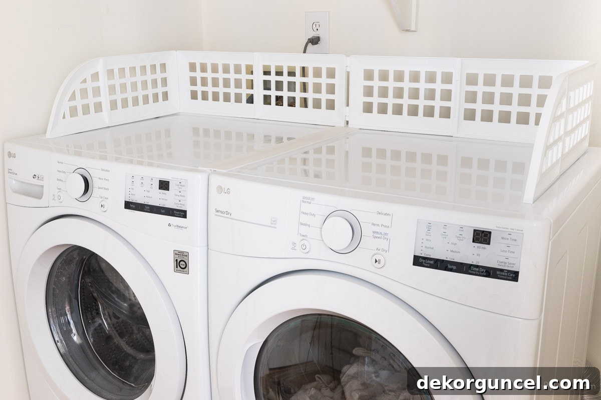 Laundry Room Storage Ideas to Maximize Your Space 16 A magnetic fence extended across the top of both a washer and dryer, providing a secure boundary for laundry items.