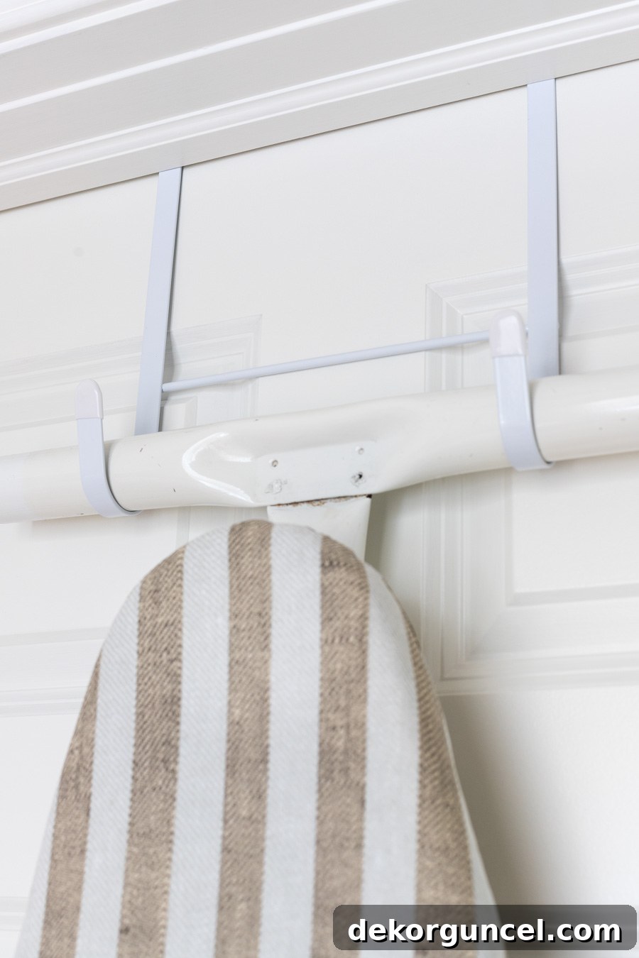 Laundry Room Storage Ideas to Maximize Your Space 8 Close-up of an ironing board hung on an over-the-door hanger, highlighting its space-saving efficiency.