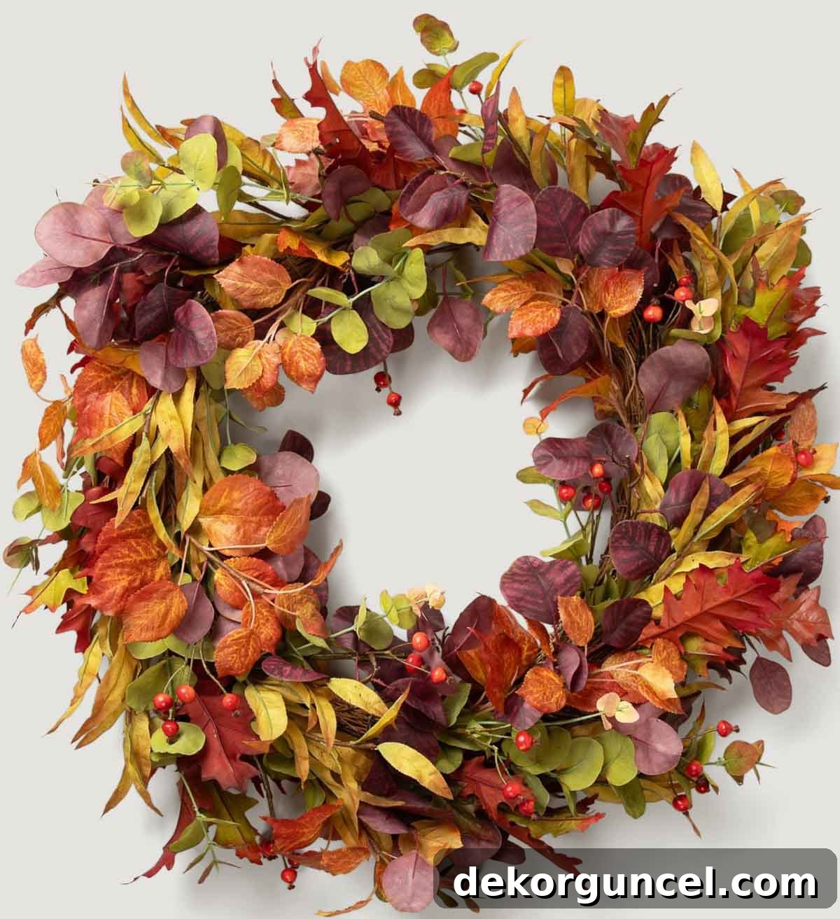 A large, sophisticated fall eucalyptus wreath adorned with faux red berries and leaves in rich shades of rust, olive, plum, and burgundy.