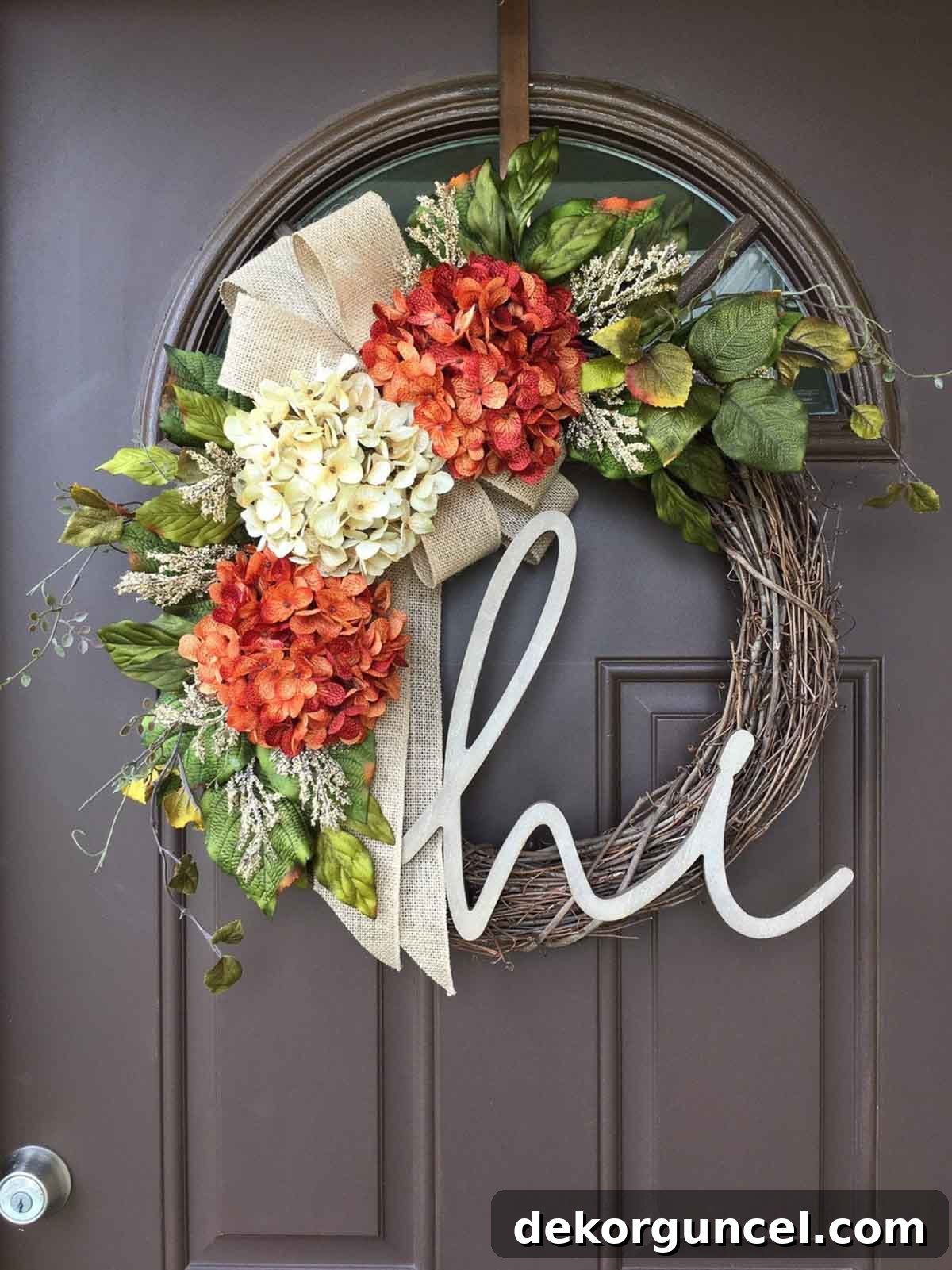 A custom fall grapevine wreath adorned with faux hydrangeas and a charming script 'hi', adding a personalized touch to your entrance.