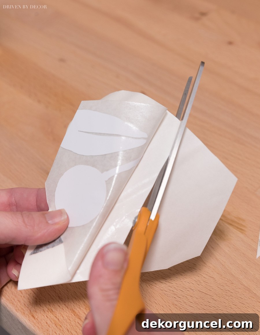 Applying a precisely cut vinyl wall decal piece using the hinge method, ensuring perfect alignment and adhesion along a wall's edge.