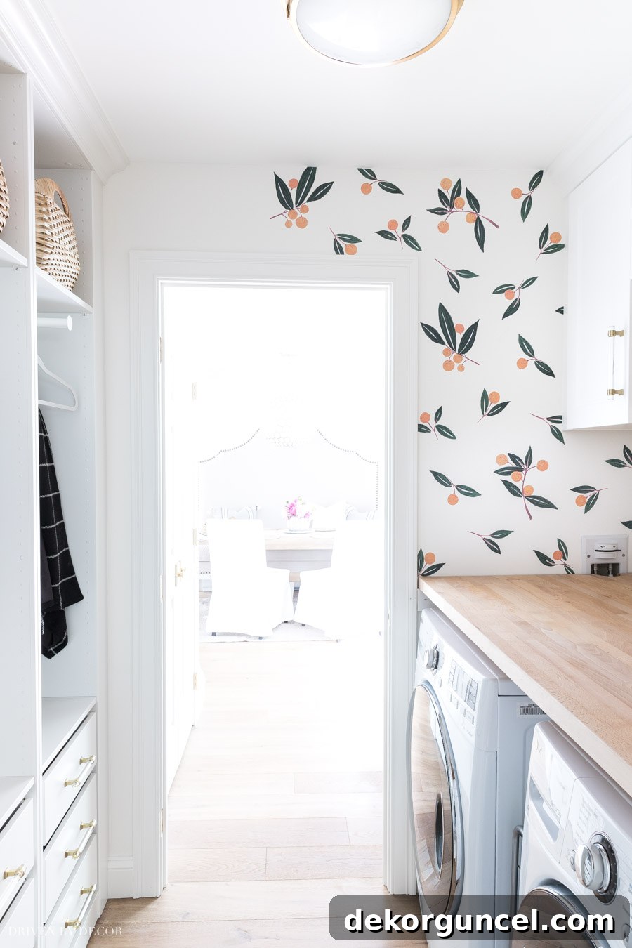 A creative view of the laundry room during the installation of tangerine vinyl wall decals, highlighting the detailed placement around fixtures.