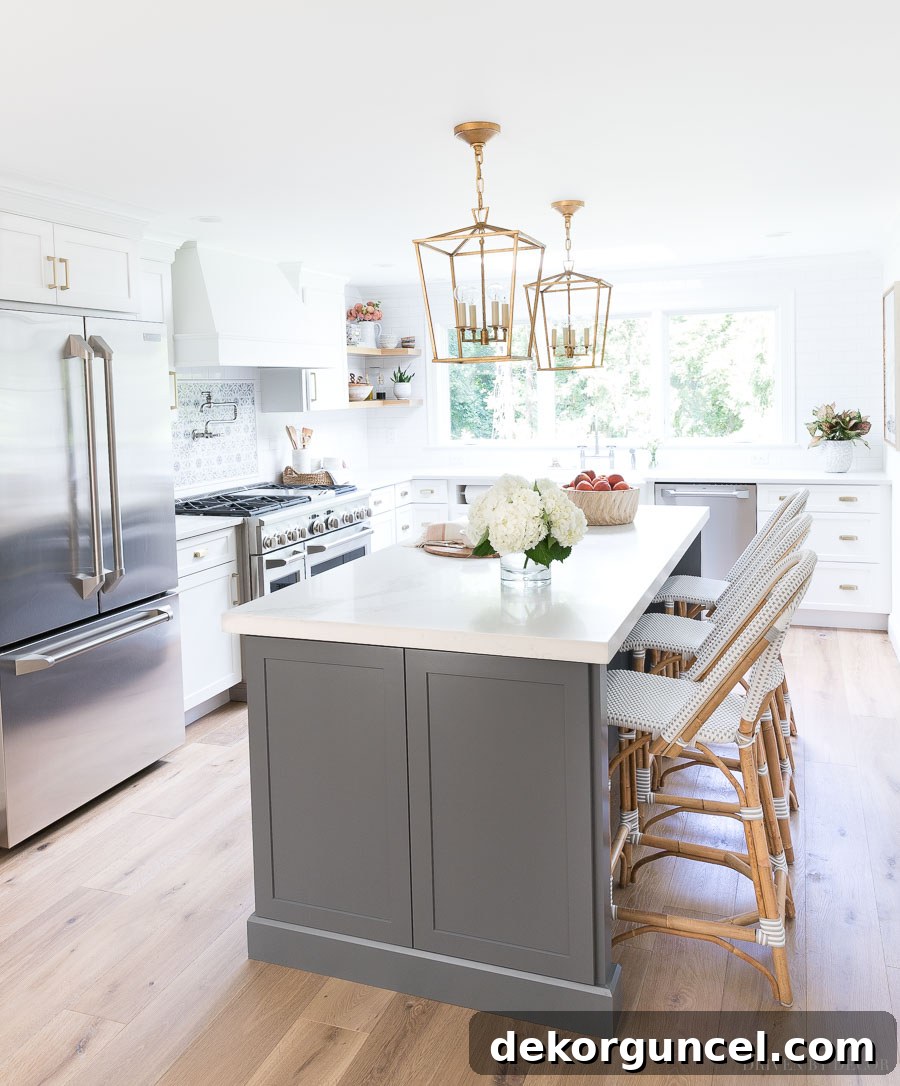 Love this newly remodeled kitchen with gray and white cabinets and brass accents! Such a huge difference from what it looked like before!