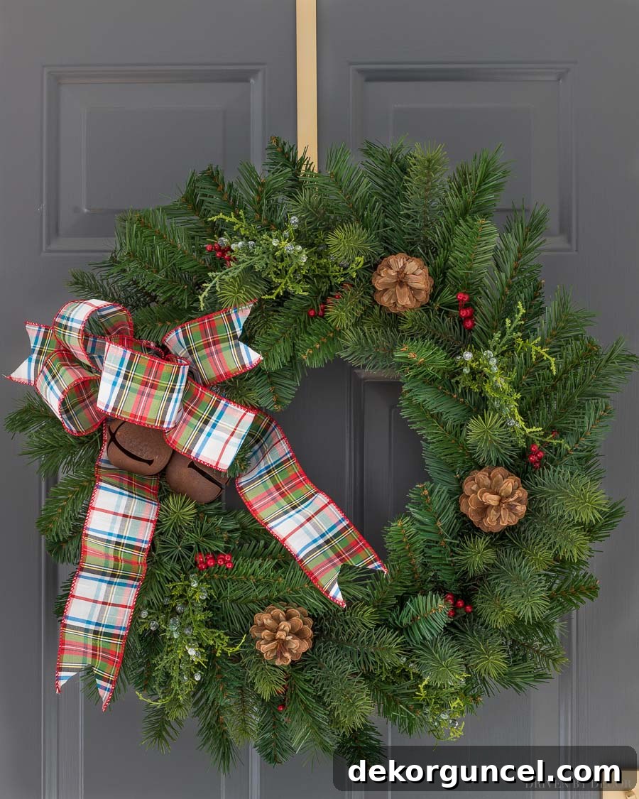 A close-up view of our gorgeous Christmas wreath, showcasing its realistic greenery and charming plaid bow details.