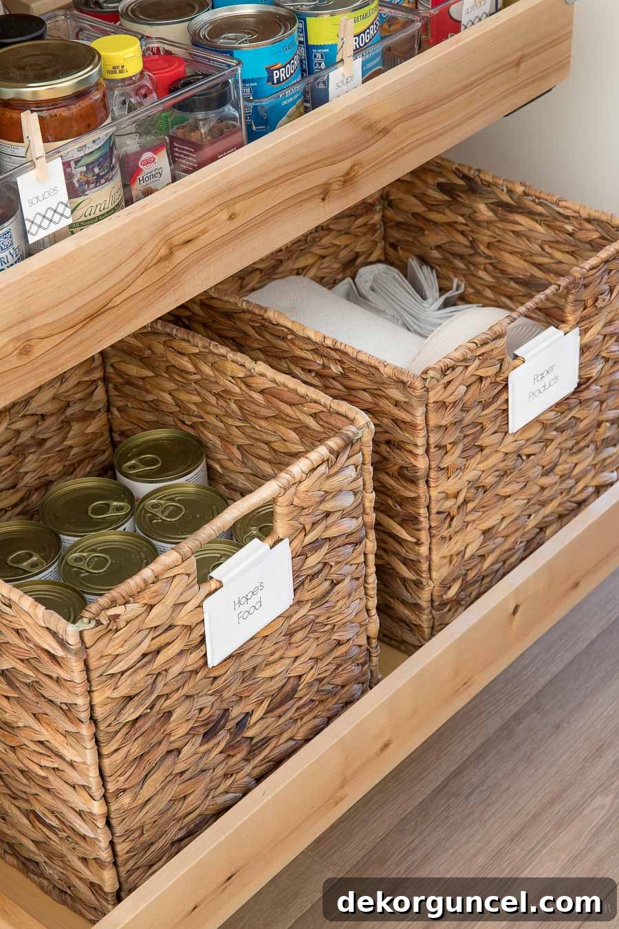 Tall woven storage baskets efficiently holding canned goods and paper products in a kitchen pantry