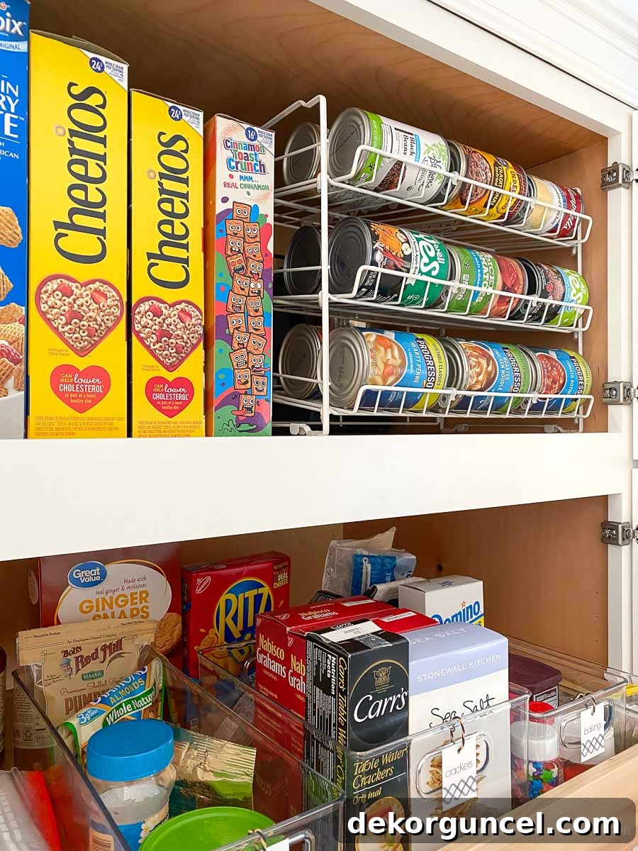 Close-up of a stacked can organizer within a kitchen cabinet, demonstrating smart pantry storage