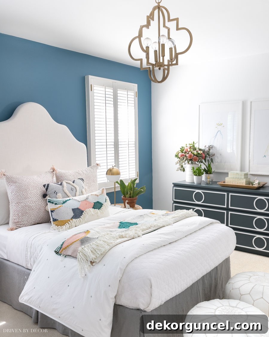 A charming bedroom featuring an accent wall painted in Behr Blueprint, a beautiful medium-toned blue.