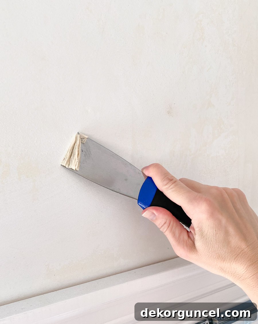 Using a putty knife to efficiently remove thick wallpaper glue residue