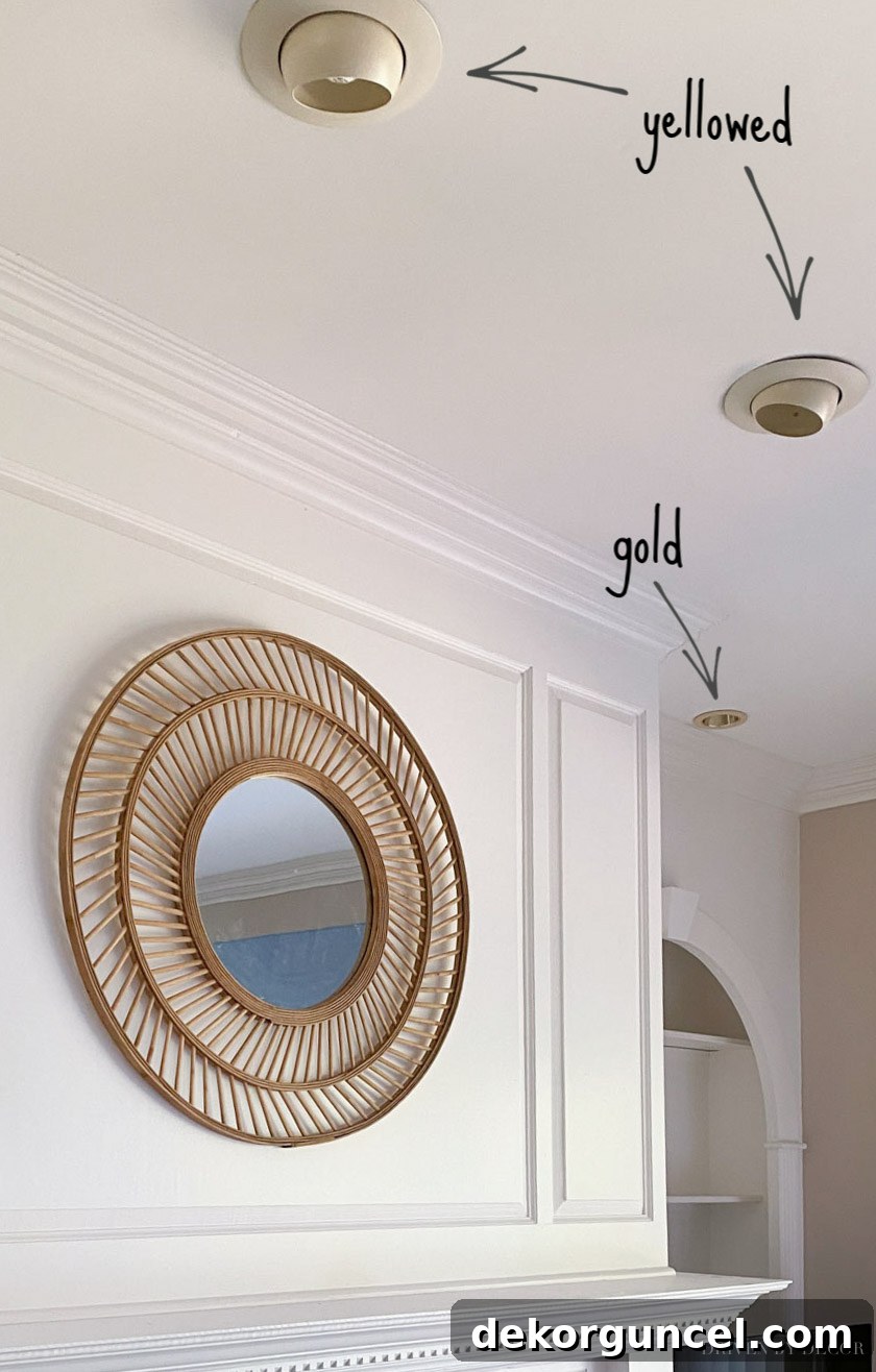 Dated gold recessed light trim before spray painting, showing its yellowed appearance against a white ceiling.