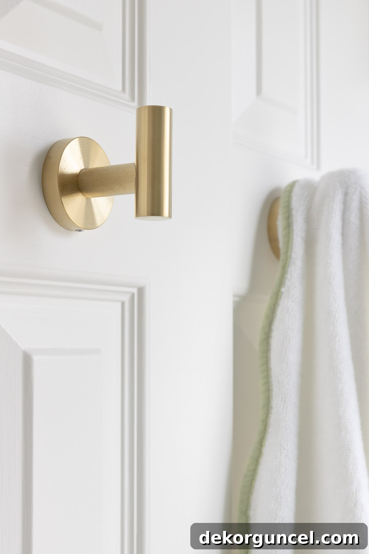 Effortless Bathroom Style for an Instant Update 16 Simple brass towel hooks installed on the back of a bathroom door