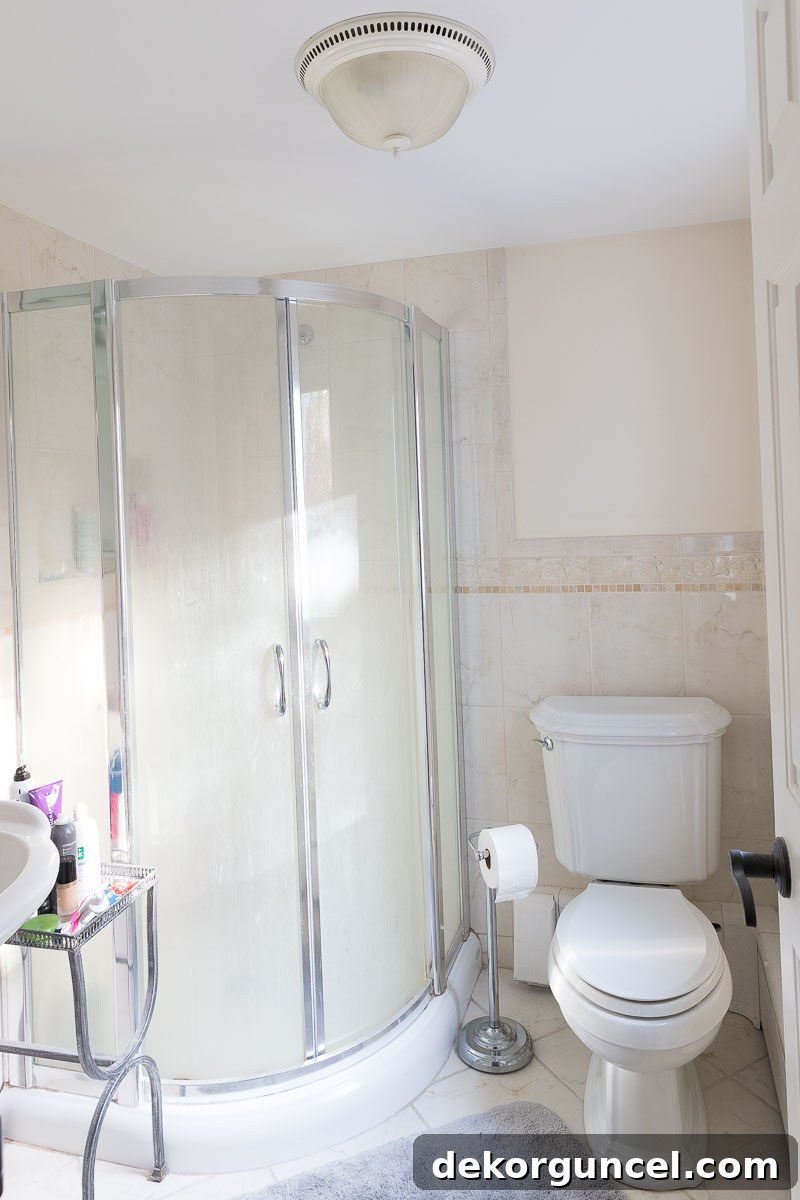 Another view of the old master bathroom, highlighting the corner shower and dated fixtures