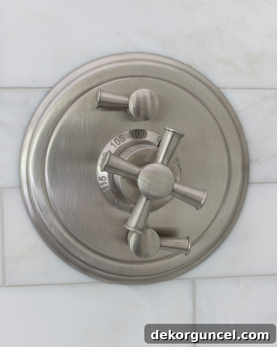 Stylish satin nickel shower valve trim with classic cross handles, enhancing the shower's aesthetic
