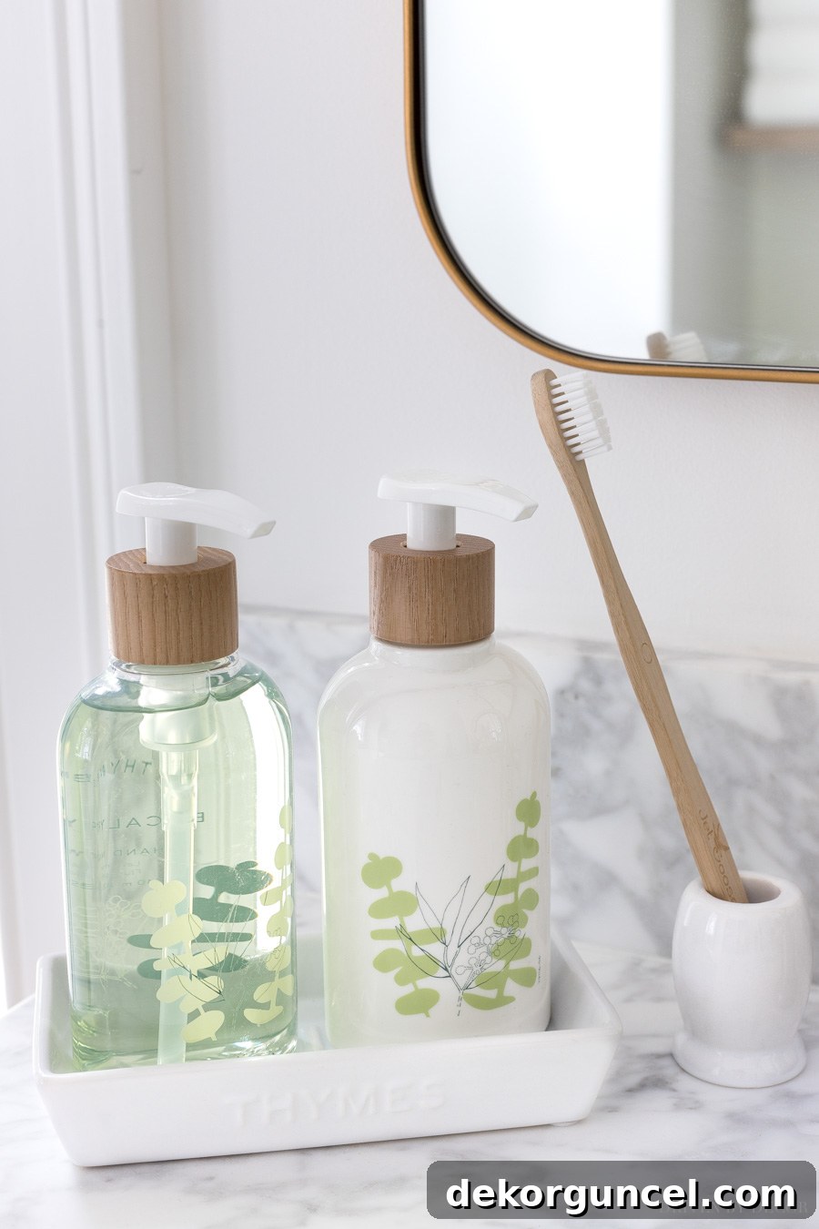 Soap and lotion pumps in a white tray by the bathroom sink, accompanied by a small, space-saving toothbrush holder