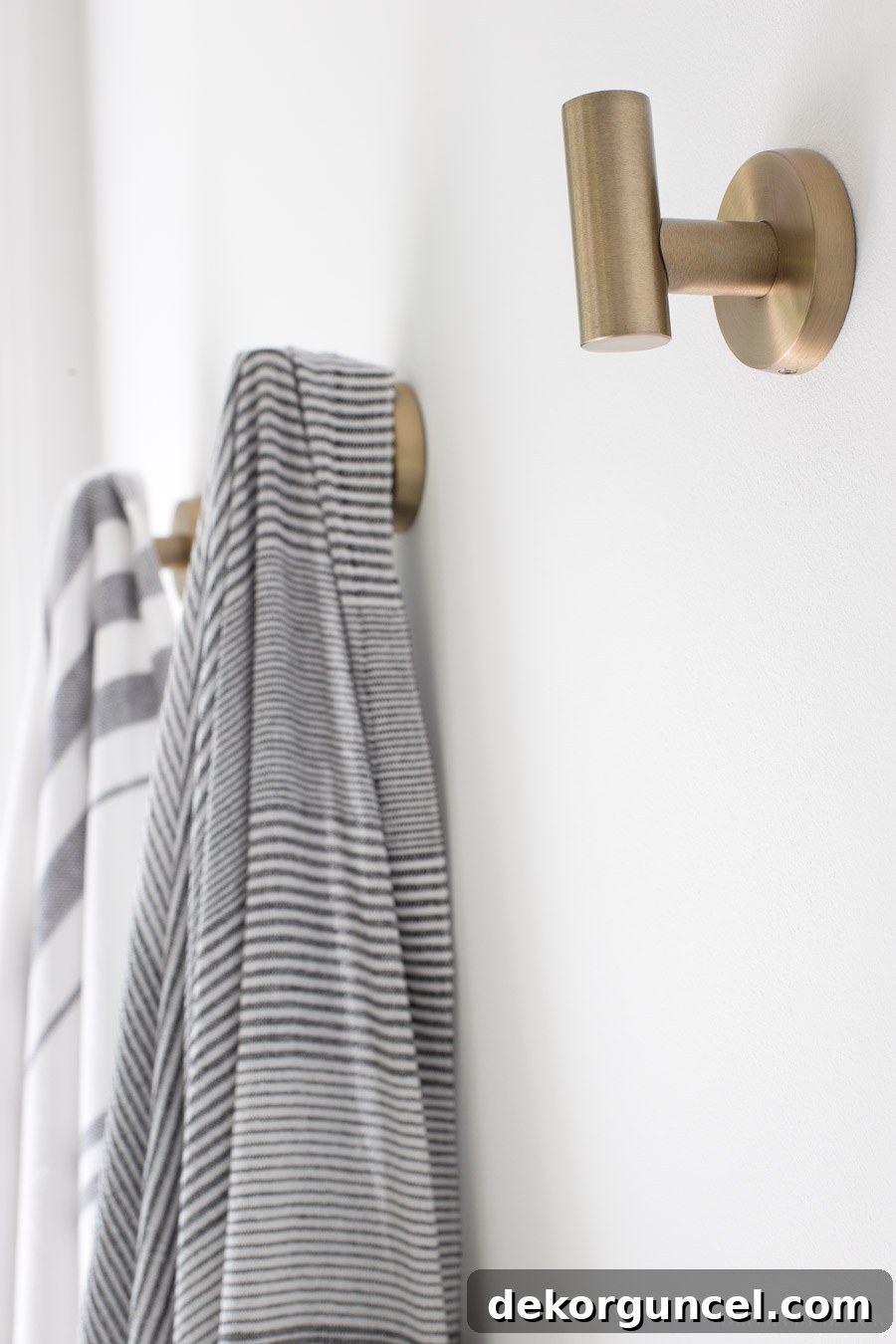 Close-up of the beautiful brass towel hooks, adding a touch of golden warmth to the master bathroom