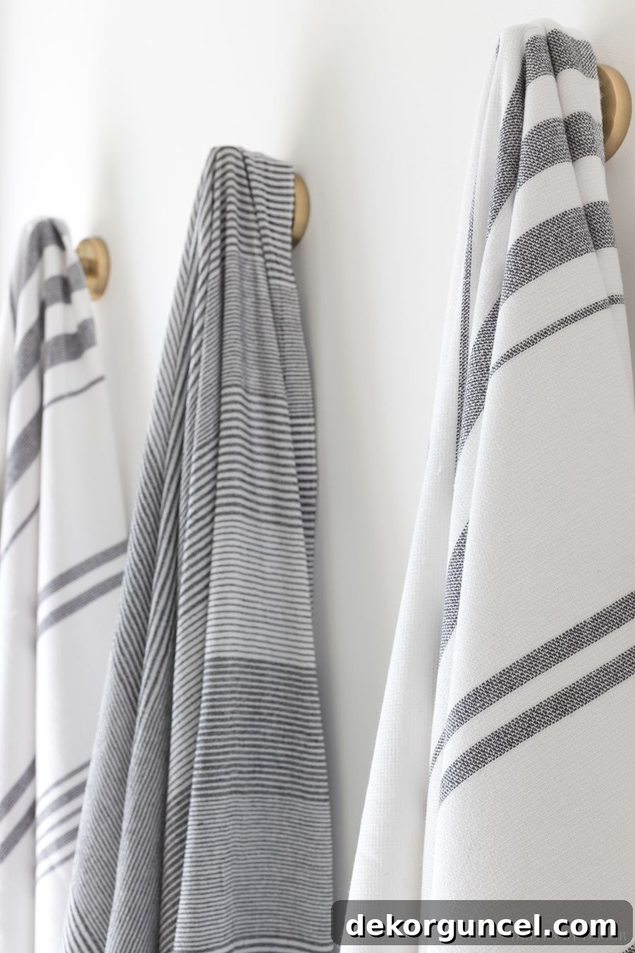 Stylish striped towels neatly hung on deep robe hooks, complementing the bathroom's decor