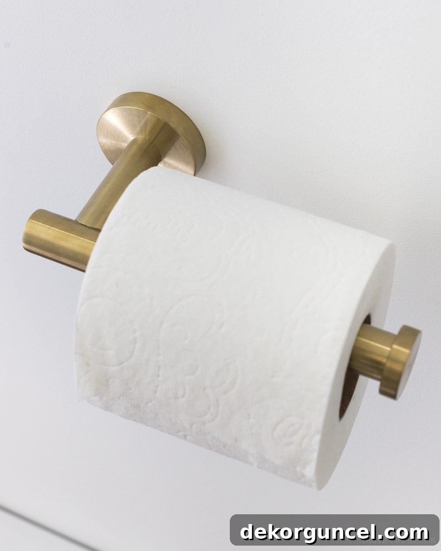 A beautiful yet affordable brass toilet paper holder, alongside other charming bathroom decor ideas