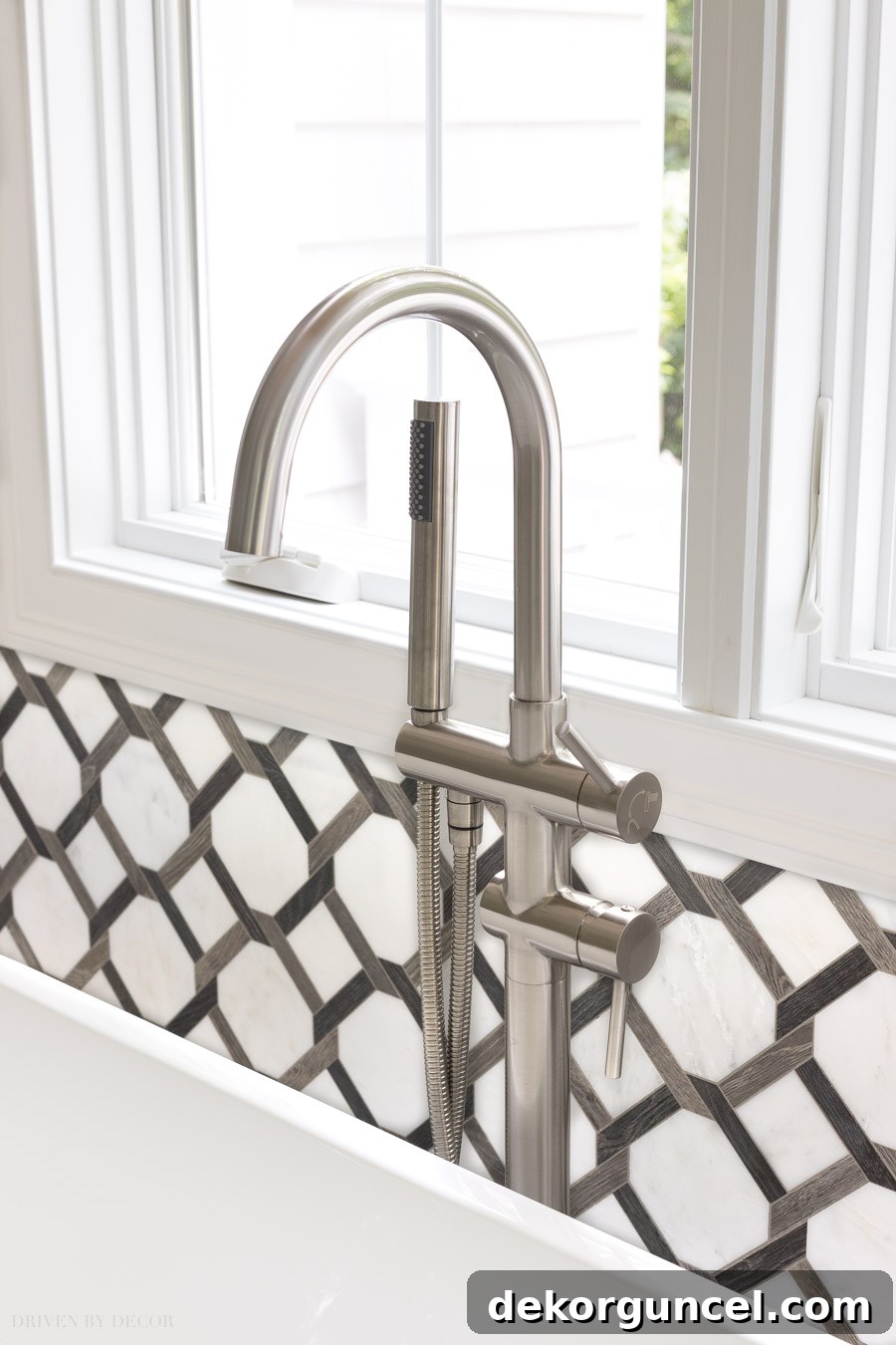 A simple, elegant freestanding tub filler in a brushed nickel finish in the master bathroom