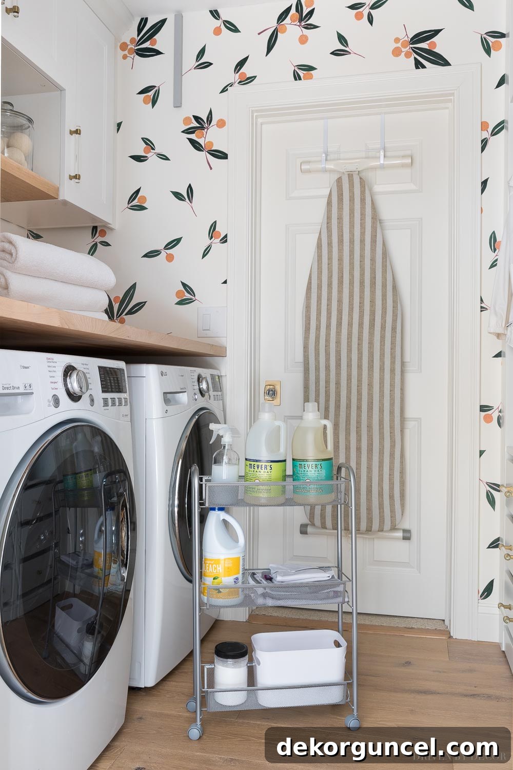 Slim rolling cart neatly tucked between a washer and dryer in a laundry room, providing accessible storage for laundry products.